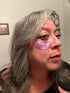 Image of a lady wearing purple under eye masks. 